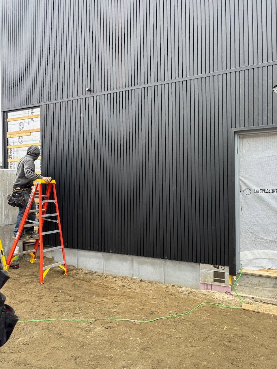 Contractor installing exterior siding for a Vermont commercial project